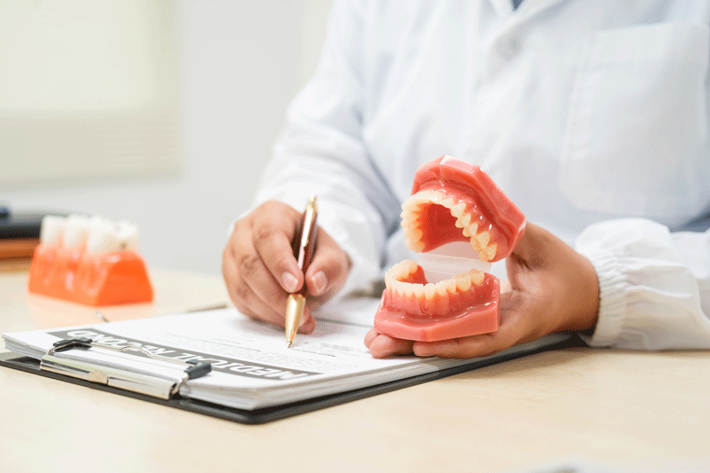 A doctor sits at a table in a hospital, discussing dental issues with a new dental patient. sitting in dental office